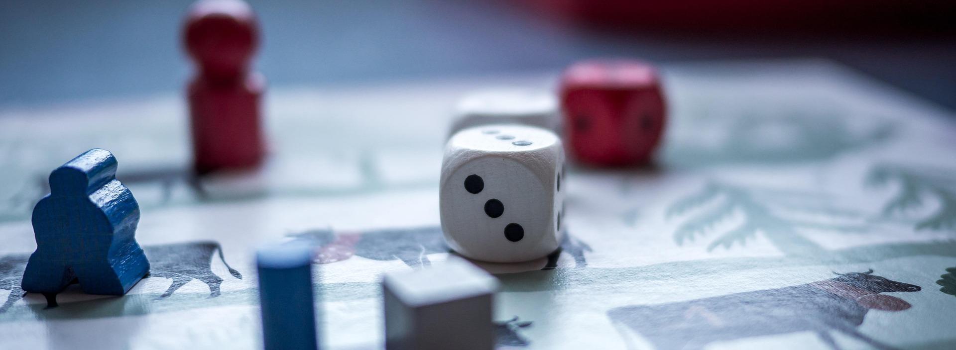 Würfel und Spielfiguren auf einem Spielbrett