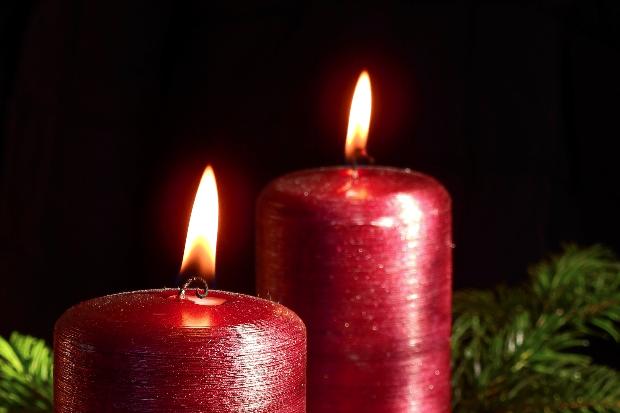 Adventsgesteck mit zwei brennenden Kerzen