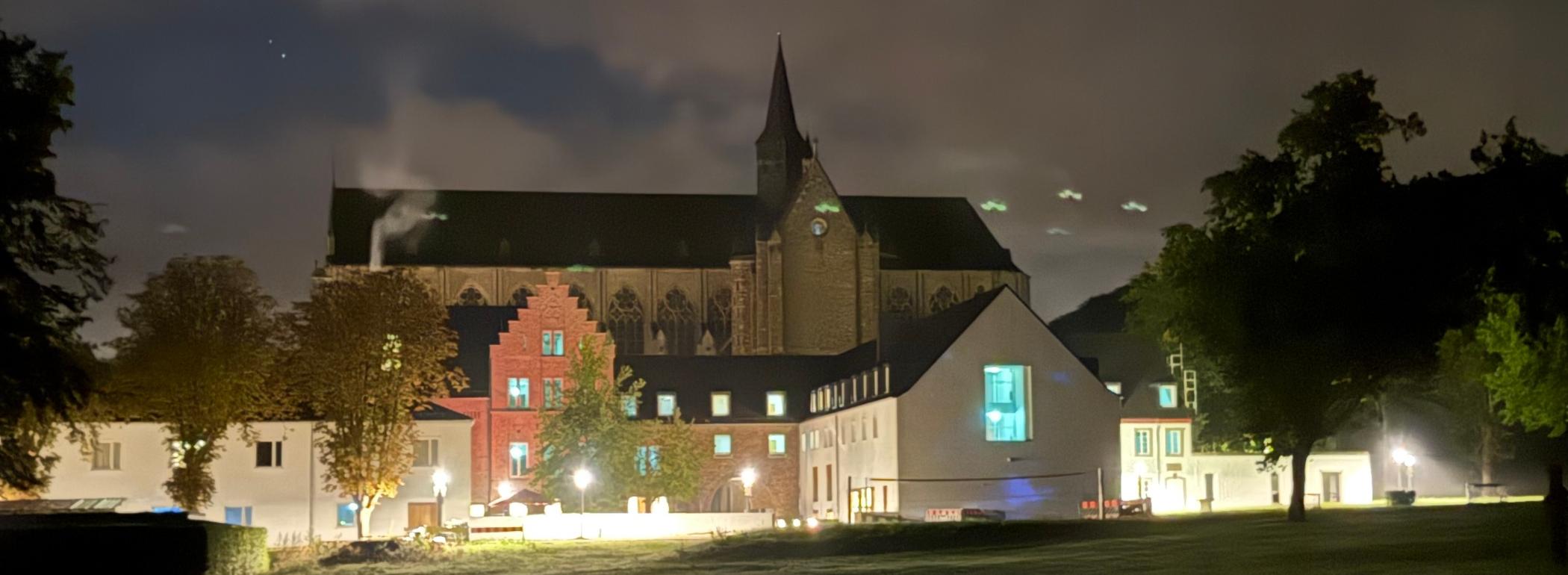 Haus Altenberg und dahinter der Dom bei Nacht erleuchtet