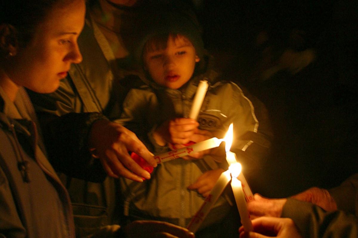 Foto wie im Dunkeln Kerzen an einer brennenden Kerze angezündet werden