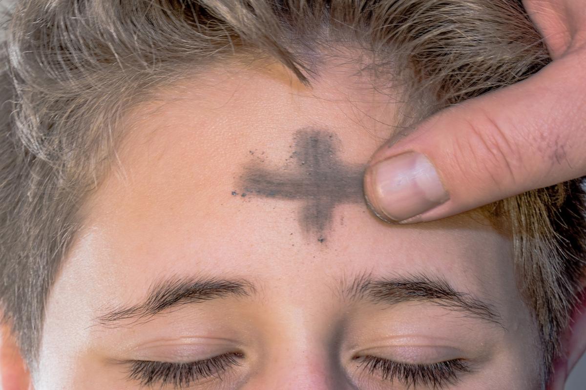 Stirn, auf die mit Asche ein Kreuz gezeichnet wird