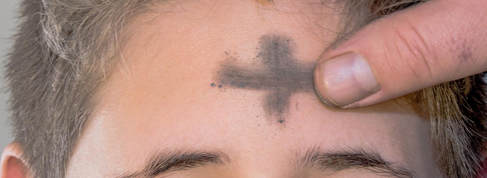 Stirn, auf die mit Asche ein Kreuz gezeichnet wird