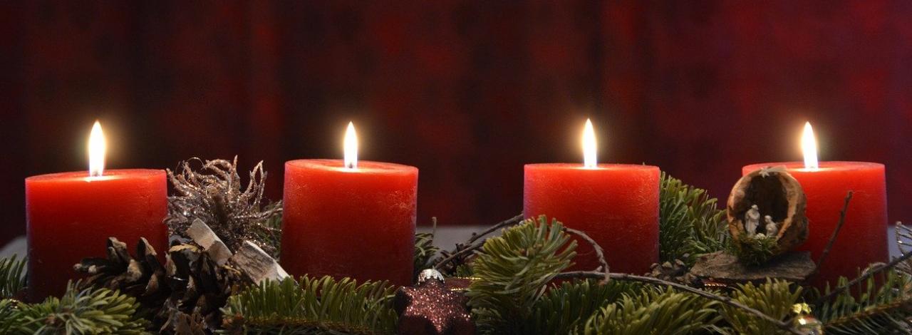 Adventsgesteck mit 4 brennenden Kerzen