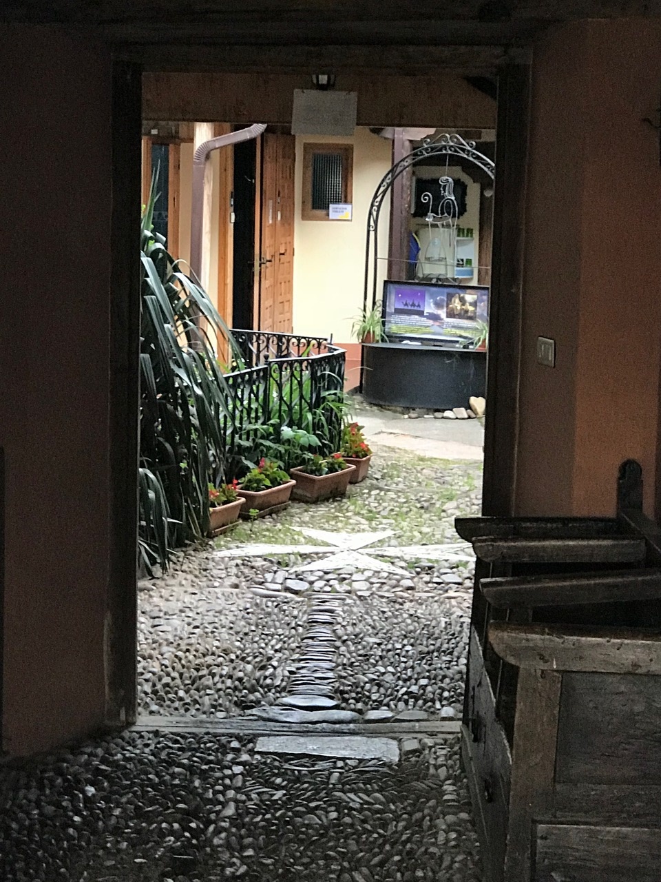 Blick durch eine geöffnte Tür in den Innenhof einer Pilgerherberge auf Jakobsweg