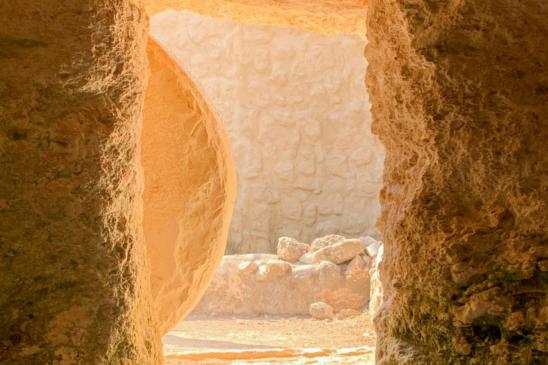 Blick aus einer Gruft durch den Eingang nach draußen. Vor dem Eingang leht ein an Seite gerollter Stein.
